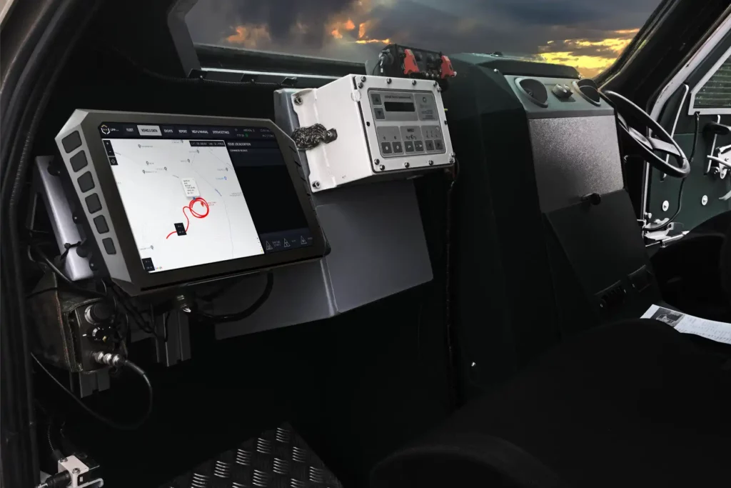 Interior of armored vehicle showing vetronics system with mission control and situational awareness interface