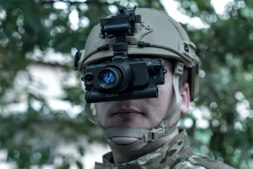 Soldier wearing helmet-mounted night vision monocular device for enhanced visibility
