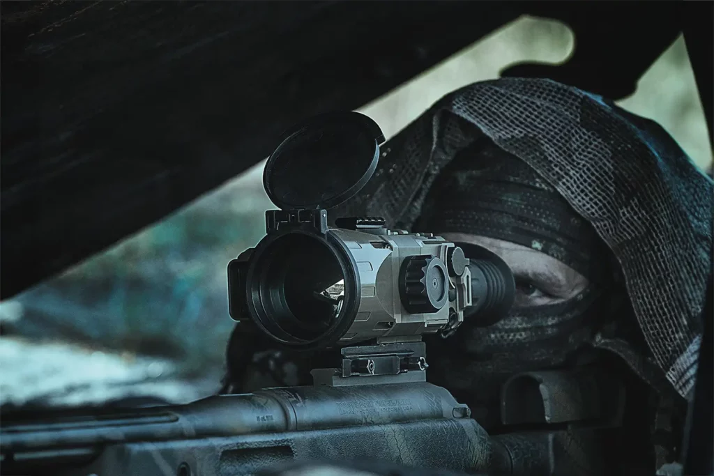TSA-7 thermal imaging scope mounted on rifle in use by camouflaged marksman