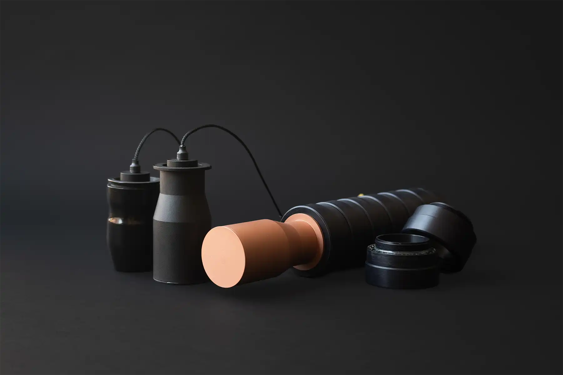 Assortment of drone warheads in black finishes, arranged on matte surface