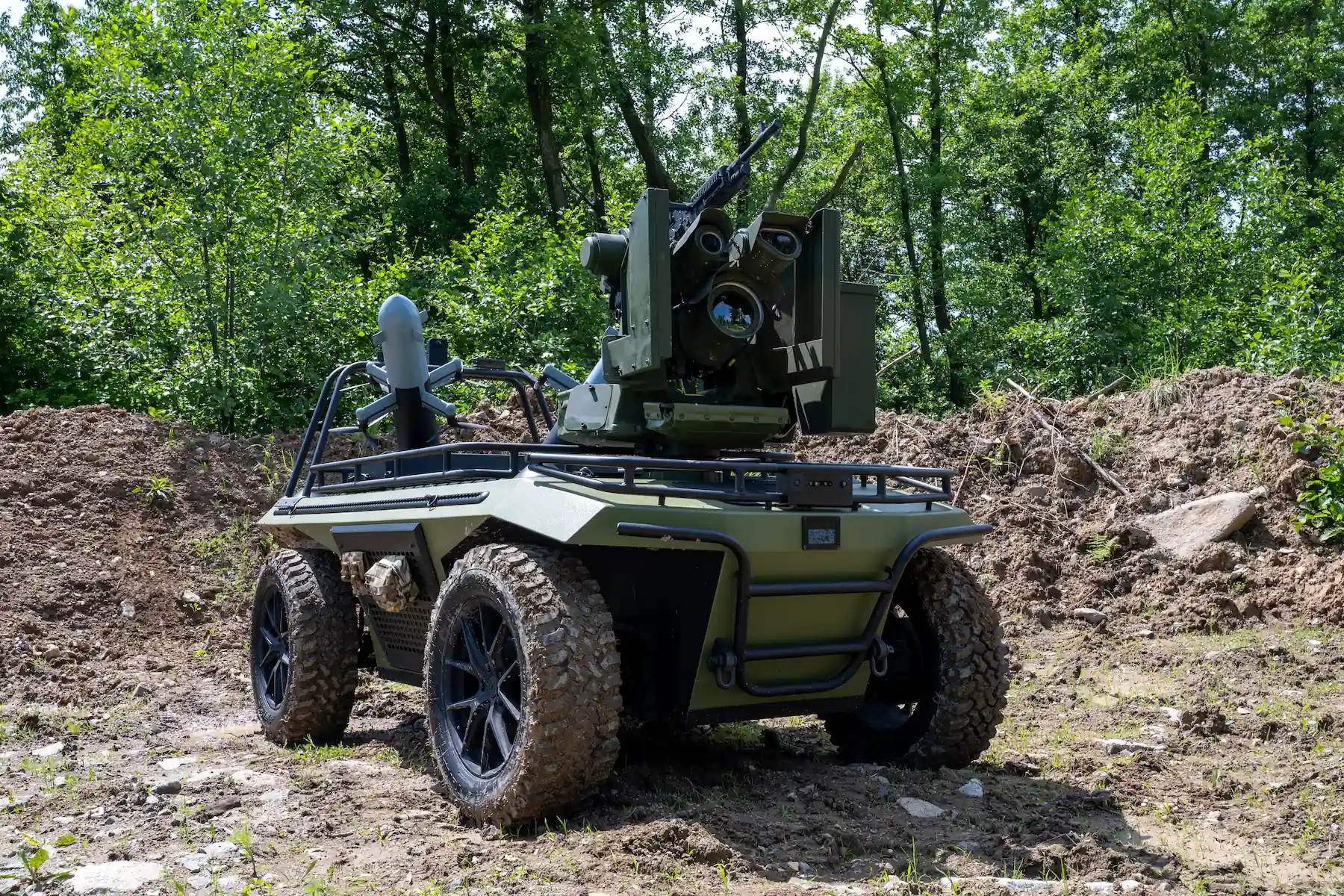 Unmanned Ground Vehicle with anti-drone turret and interceptor drones in terrain